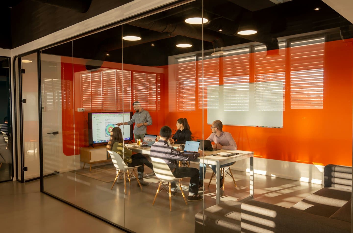 Contact Business team meeting in a modern conference room with a screen.