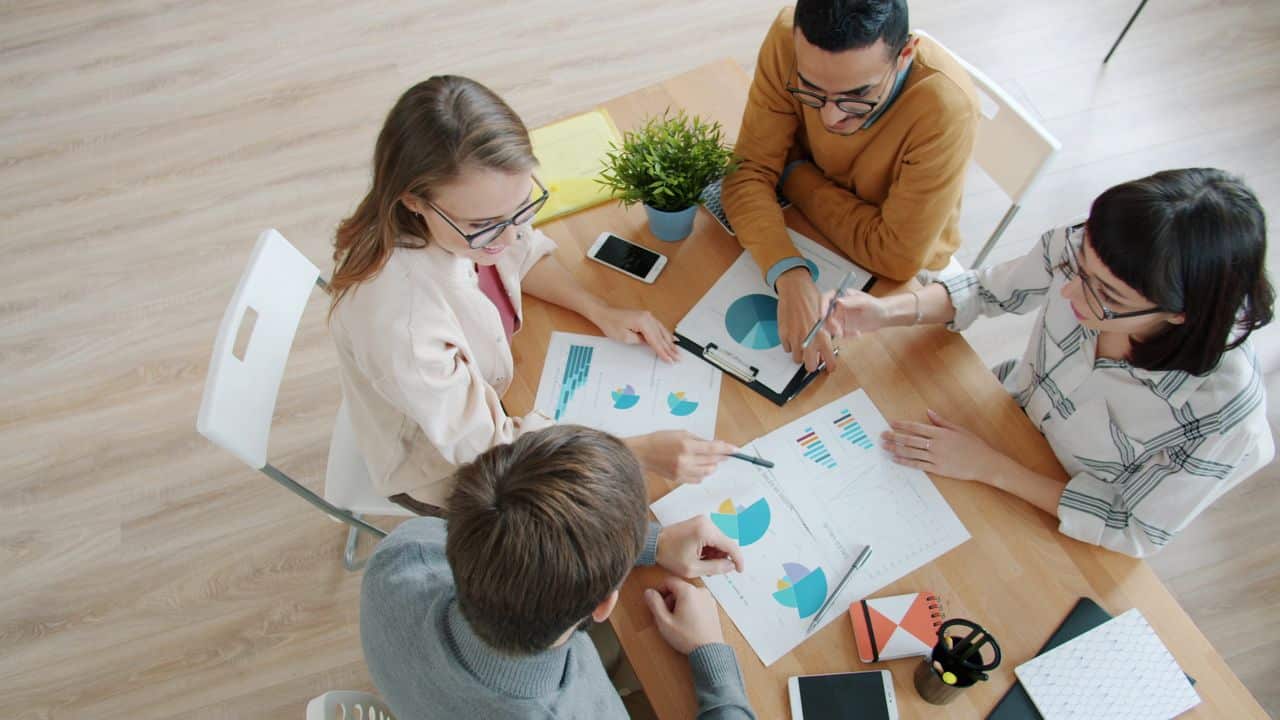 About Diverse team collaborating on data analysis with charts and smartphones.