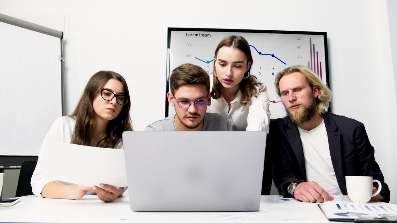 The Art of Drawing Readers In: Your attractive post title goes here Business team engaged in a collaborative meeting using a laptop to discuss strategies.