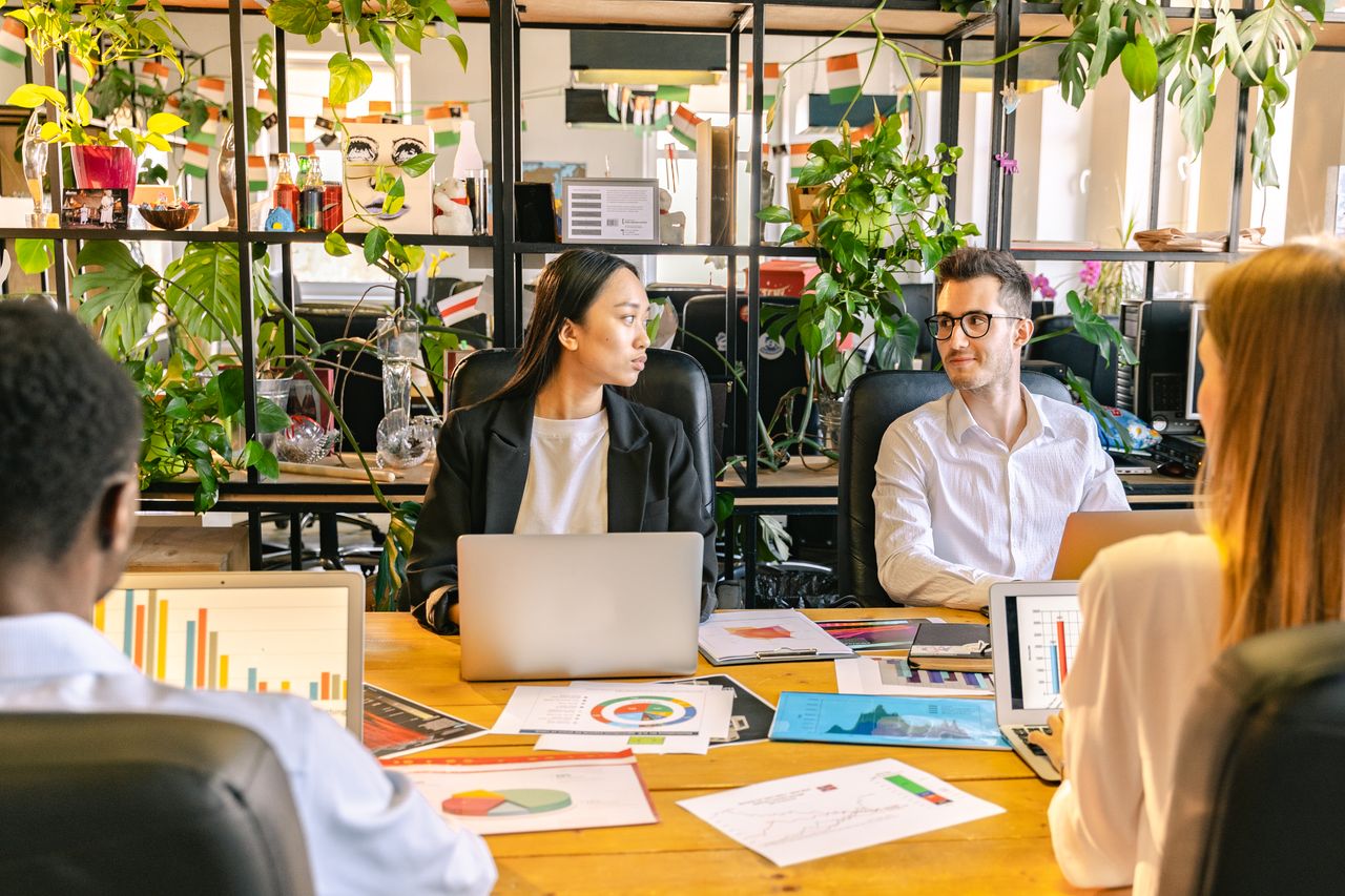 Crafting Captivating Headlines: Your awesome post title goes here A diverse team of professionals discussing projects in a plant-filled office setting.